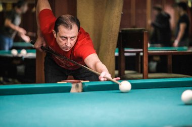 Oyuncu bilardoda topa nişan alıyor.