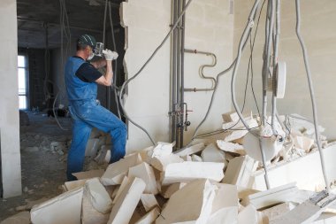 işçi yıkılan duvardan enkaz kaldırır