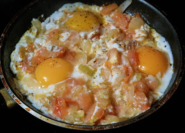 Los huevos frescos y las patatas se fríen en una sartén — Foto de Stock