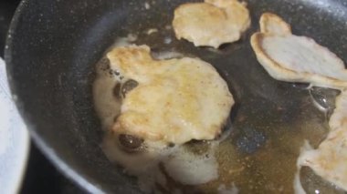 Golden chicken legs in batter fried in a pan