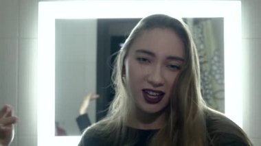 young beautiful girl posing in front of a mirror in slow motion