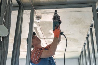 Bir işçi alçıpandan duvar yapar.