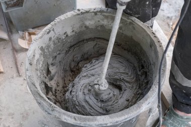 İşçi kovada çimento harcı yoğurur