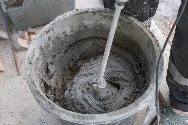 İşçi kovada çimento harcı yoğurur