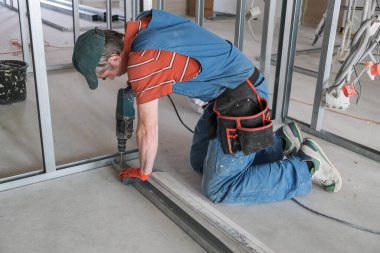 Bir işçi alçıpandan duvar yapar.