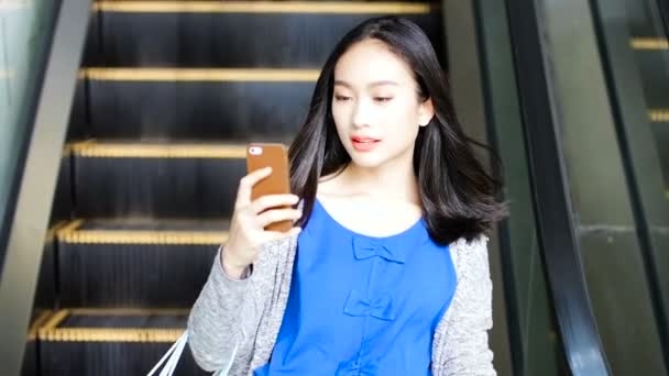 Girl watching mobile and chatting with friends after shopping. — Stock Video