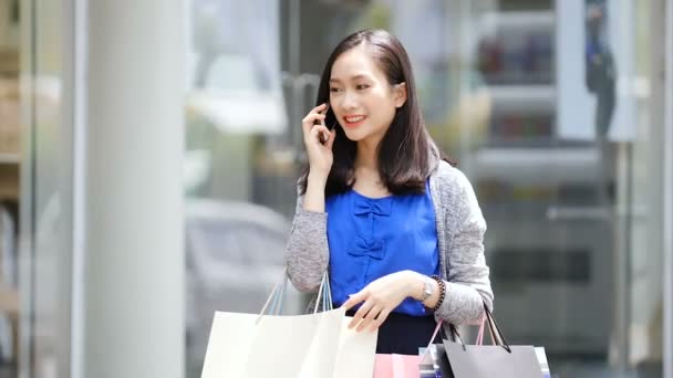Aziatisch meisje gesprekken over de telefoon, ze is gelukkig en chatten met haar vrienden. — Stockvideo