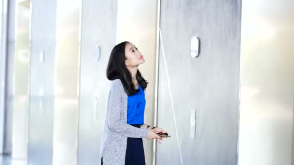 Asian girl pushes the elevator to go in on the building. — Stock Video