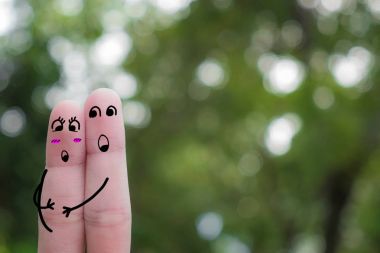 Mutlu bir çift parmak sanatı. Mutlu hamile kadın ve kocası parkta. Mutlu bir çift aşık boyalı gülen ve sarılma. Mavi gökyüzü background.fingers aşık kucaklayan parmak Çift