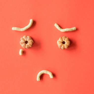 Yüz şeklinde kurabiyeler. Pembe bir arka plan üzerinde çiçek kurabiye kek. Düz yatıyordu.