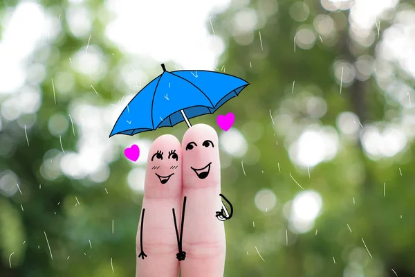 Finger art of a Happy couple. A man and a woman hug with pink hearts in the eyes. The concept of love at first sight.rainy season