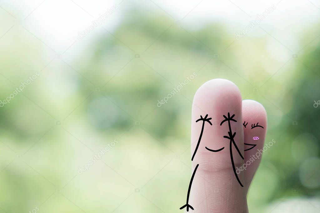 Finger art of a Happy couple. A man and a woman hug with pink hearts in the eyes. The concept of love at first sight..
