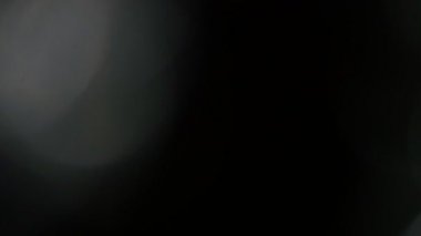 Işık darbeleri ve glows.beautiful hafif sızıntı ile koyu arka plan üzerinde 4 k hd kalitesinde. Gerçek mercek parlaması ve hafif sızıntı.