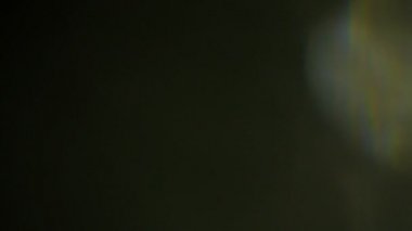 Işık darbeleri ve glows.beautiful hafif sızıntı ile koyu arka plan üzerinde 4 k hd kalitesinde. Gerçek mercek parlaması ve hafif sızıntı.