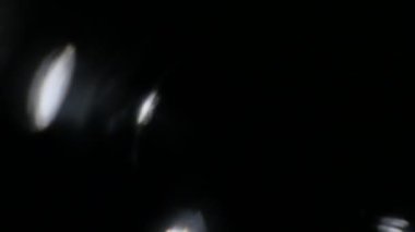 Işık darbeleri ve glows.beautiful hafif sızıntı ile koyu arka plan üzerinde 4 k hd kalitesinde. Gerçek mercek parlaması ve hafif sızıntı. Mükemmel kompozisyon için.