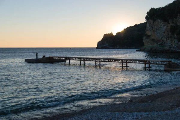 Träbrygga på tomma stranden vid solnedgången — Stockfoto