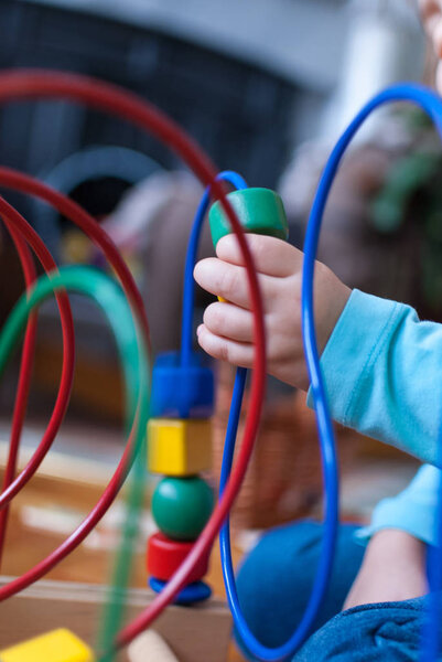 Child's hand close up playing with colorful shapes 