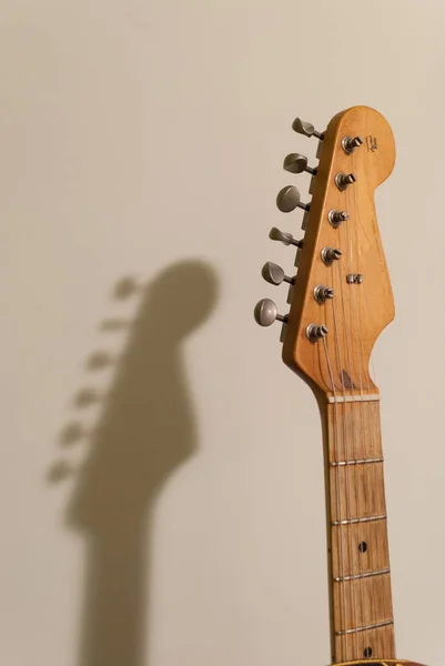 Vintage getragene E-Gitarre Kopf und Hals in Großaufnahme mit Schatten an der Wand — Stockfoto