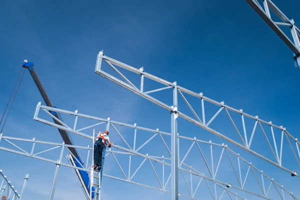 Guindaste de elevação de aço galvanizado telhado treliça estruturas de construção e trabalhador de construção montando os elementos — Fotografia de Stock