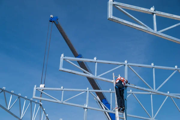 Guindaste de elevação de aço galvanizado telhado treliça estruturas de construção e trabalhador de construção montando os elementos — Fotografia de Stock