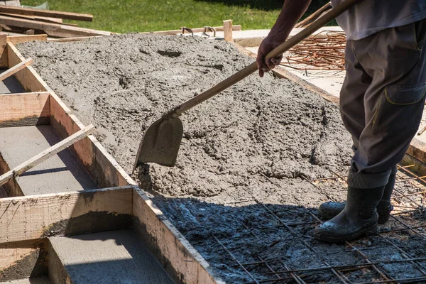 Pekerja menyebarkan beton yang dituangkan — Stok Foto