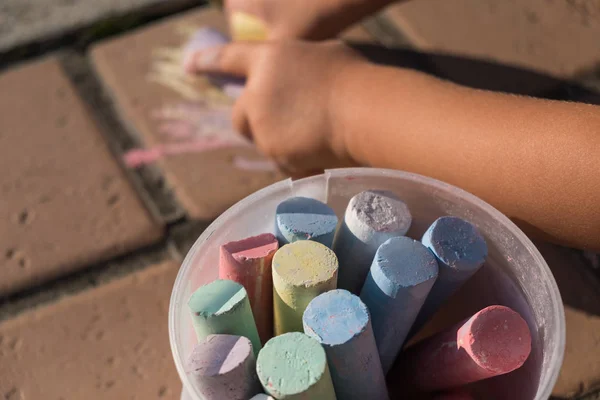 Kaldırımda bir plastik kova tebeşirler renklendirme Grup — Stok fotoğraf