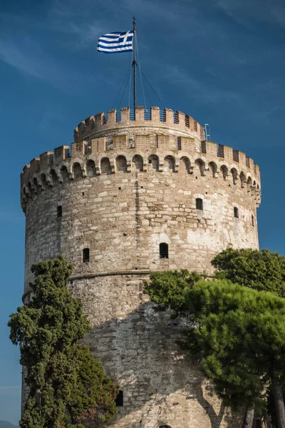 Üstünde belgili tanımlık tepe Yunan bayrağı ile antik taş kule