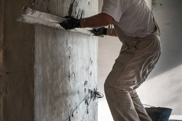 Worker leveling the cement plaster coating