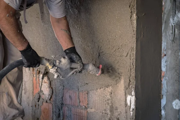 Construction worker applying cement plaster