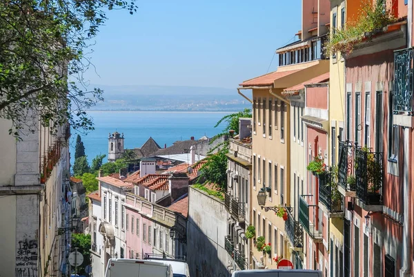 Steep streets of Lisbon, Portugal with ocean in the background