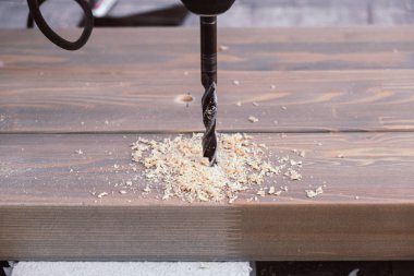 Bir marangoz tarafından matkapla ahşap kalaslarda delik açılmış.