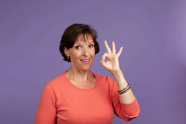 Pretty middle Age woman giving Okay sign — Stock Photo, Image