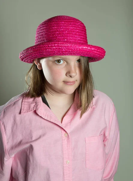 Menina de onze anos de idade em blusa rosa de grandes dimensões e chapéu rosa — Fotografia de Stock