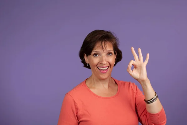 Hübsche Frau mittleren Alters gibt Okay — Stockfoto