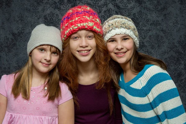 Три молоді дівчата у вовняних капелюхах Стокове Зображення
