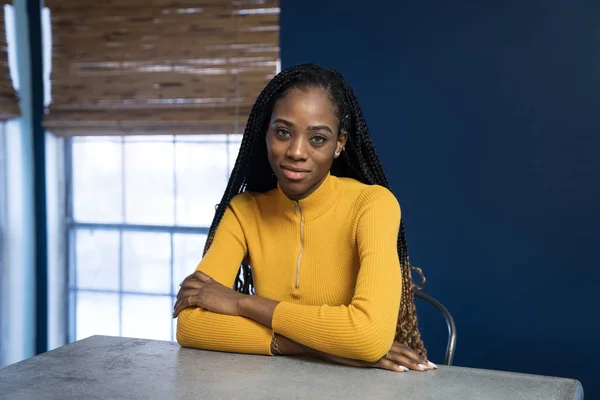 Young African American woman with yellow shirt sitting at the ki — Stock Photo, Image