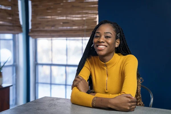 Young African American woman with yellow shirt sitting at the ki — Stock Photo, Image