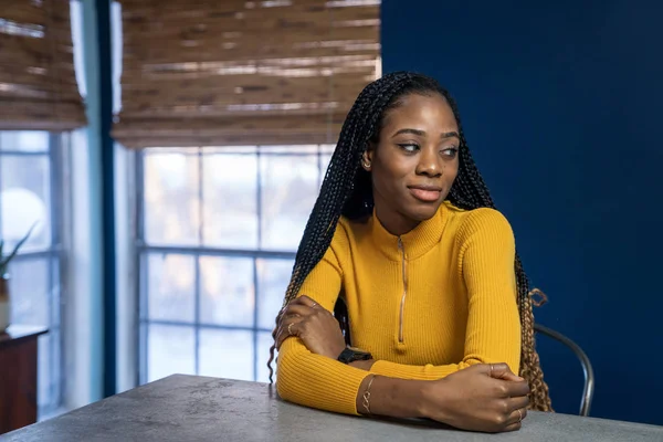 Young African American woman with yellow shirt sitting at the ki — Stock Photo, Image