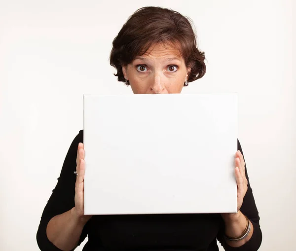 Egy nő, aki üres fehér táblát tart, és helyet ad a másolatodnak. — Stock Fotó