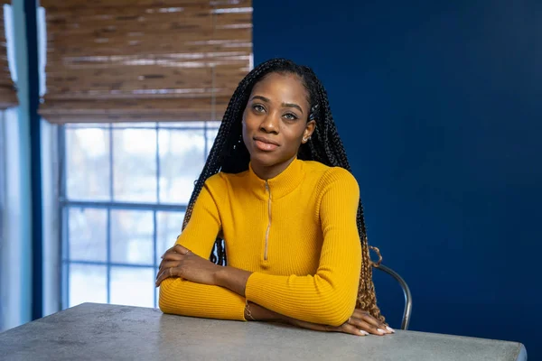 Young African American woman with yellow shirt sitting at the ki — Stock Photo, Image