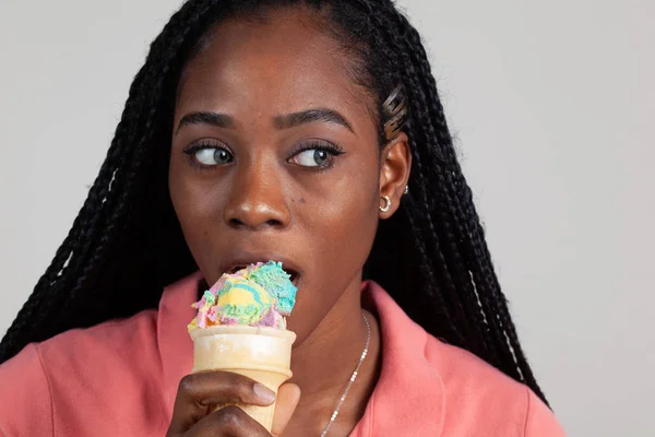 Ung afroamerikansk kvinna njuter av en flerfärgad glass — Stockfoto