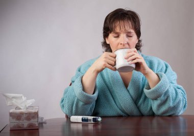 kadın kötü bir soğuk bir kupa tutan bir banyo