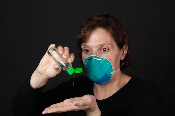 手部清洁剂 使用手部清洁剂的带医院级面罩的妇女 大流行病的隐喻概念 — 图库照片