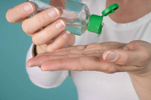 Woman putting hand sanitizer in her hand. Hand hygiene infection prevention concept.