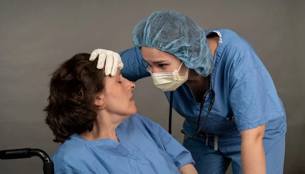 Nurse comforts an exhausted coleage. Stress and fatigue in a healthcare setting image.