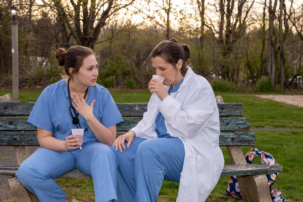 Twee Zielige Verpleegsters Operatiekleding Nemen Een Pauze Buiten Een Voorjaarsavond — Stockfoto