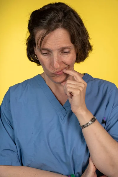 Уставшая медсестра на желтом фоне — стоковое фото