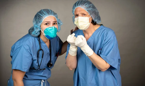 Frustrated nurse with clenched fists being consoled Stock Picture