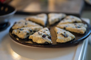 Yaban mersinli çörekler, yuvarlak bir çarşaf üzerinde üçgen şeklinde kesilmiş..