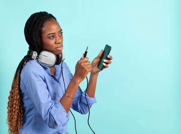 レトロな有線ヘッドフォンを持つアフリカ系アメリカ人の若い女性. — ストック写真